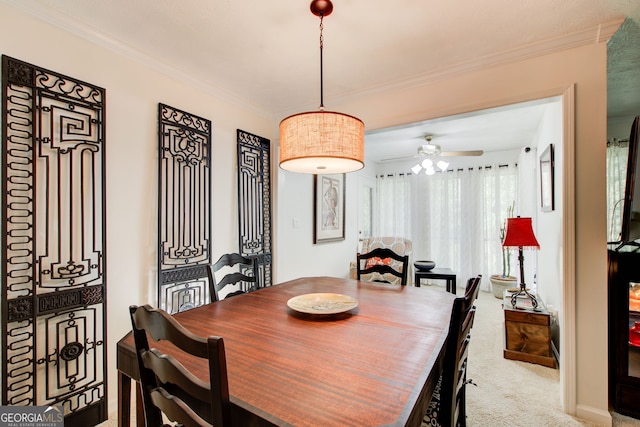 dining room featuring crown molding, light colored carpet, and ceiling fan