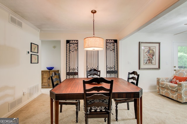 carpeted dining space featuring crown molding