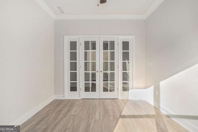 spare room with wood-type flooring, french doors, ornamental molding, and ceiling fan