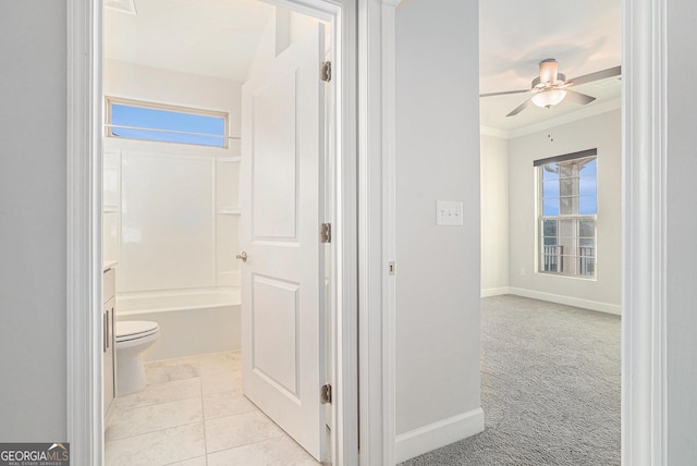 bathroom with ceiling fan, crown molding, shower / bathing tub combination, tile patterned flooring, and toilet