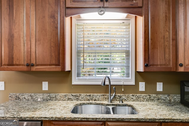 kitchen with light stone countertops and sink