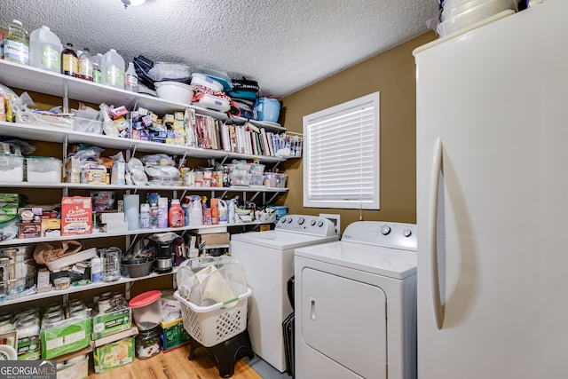 washroom featuring a textured ceiling, light hardwood / wood-style flooring, and separate washer and dryer