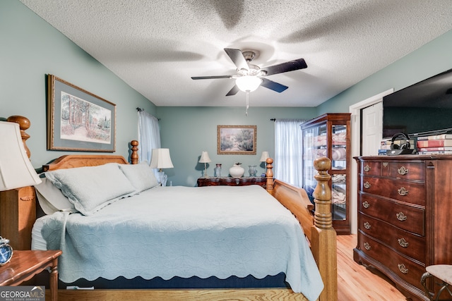 bedroom featuring a textured ceiling, light hardwood / wood-style floors, and ceiling fan