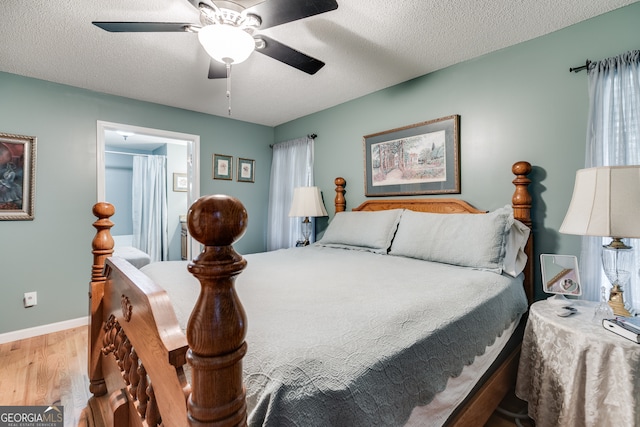 bedroom with ceiling fan, hardwood / wood-style flooring, and a textured ceiling