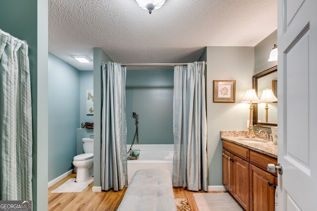 full bathroom with vanity, shower / bath combo with shower curtain, hardwood / wood-style flooring, and toilet