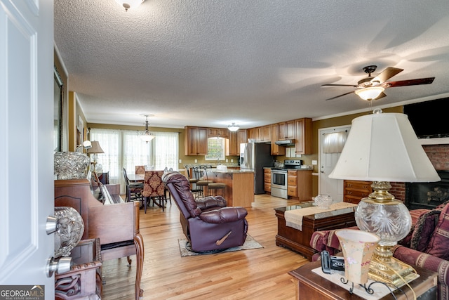 living room featuring light hardwood / wood-style flooring, a textured ceiling, and ceiling fan