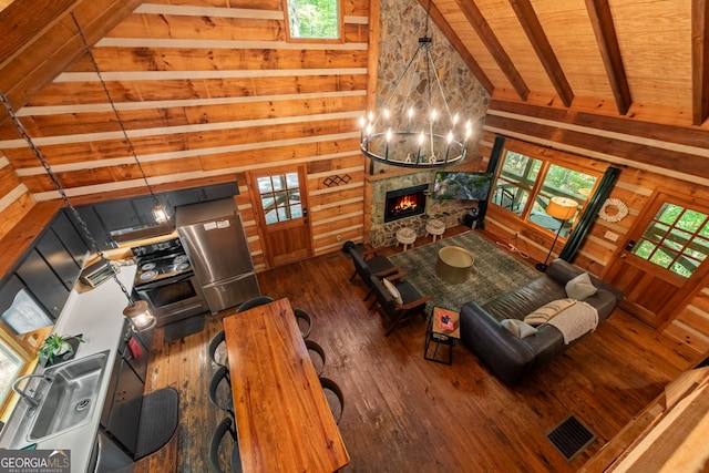 living room with wood walls, wood ceiling, high vaulted ceiling, dark hardwood / wood-style flooring, and beam ceiling