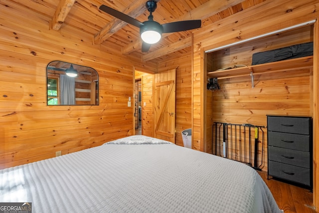 bedroom with ceiling fan, wooden ceiling, beamed ceiling, and wood walls