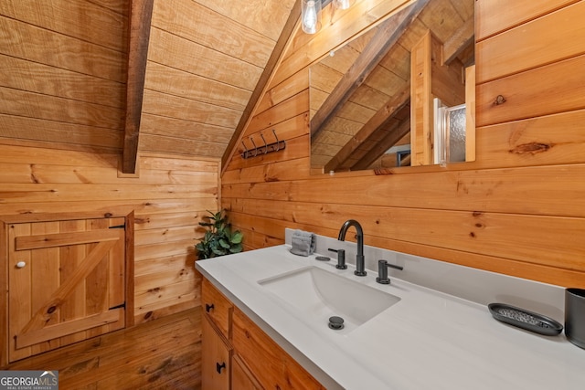 bathroom featuring vanity, vaulted ceiling with beams, wooden ceiling, and wood walls