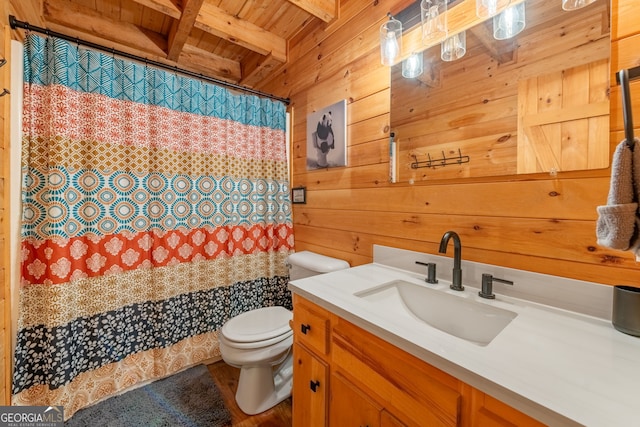 bathroom featuring wooden walls, beamed ceiling, vanity, toilet, and wooden ceiling