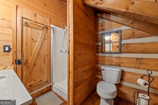 bathroom with toilet, vanity, wooden walls, and a shower with shower door