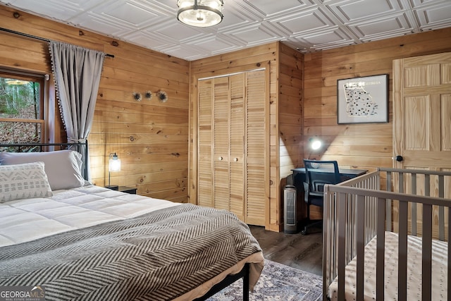 bedroom with dark hardwood / wood-style flooring and a closet