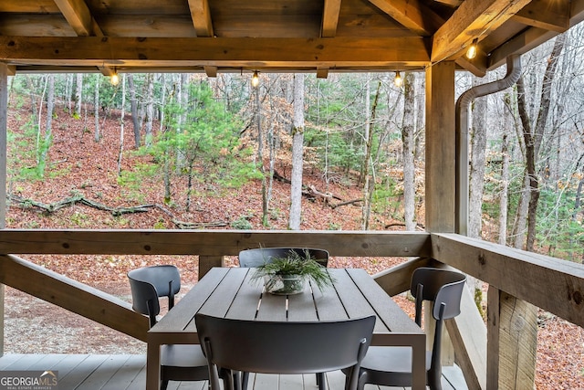 sunroom / solarium featuring beamed ceiling