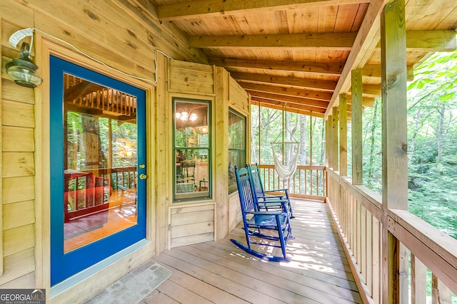 sunroom featuring wood ceiling, a healthy amount of sunlight, and lofted ceiling with beams