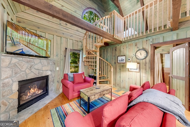 living room featuring wooden walls, a fireplace, and a wealth of natural light