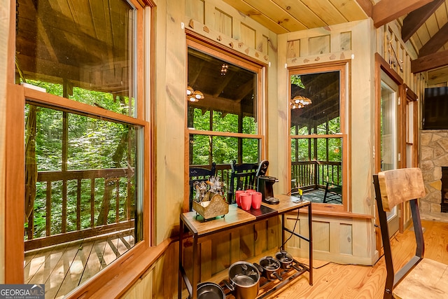 sunroom featuring vaulted ceiling, wood ceiling, and plenty of natural light