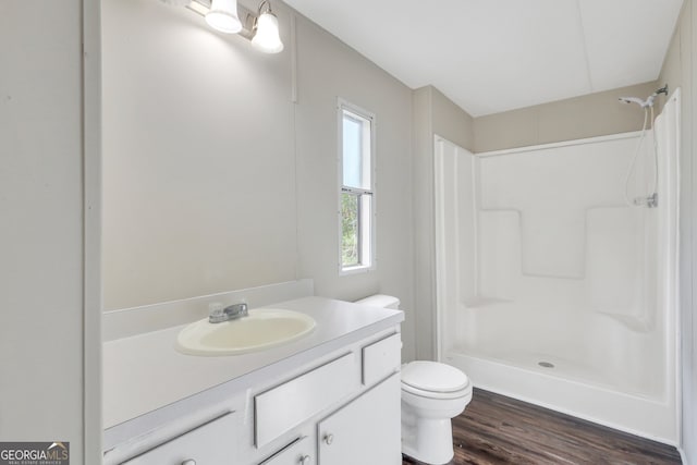 bathroom featuring vanity, toilet, walk in shower, and wood-type flooring