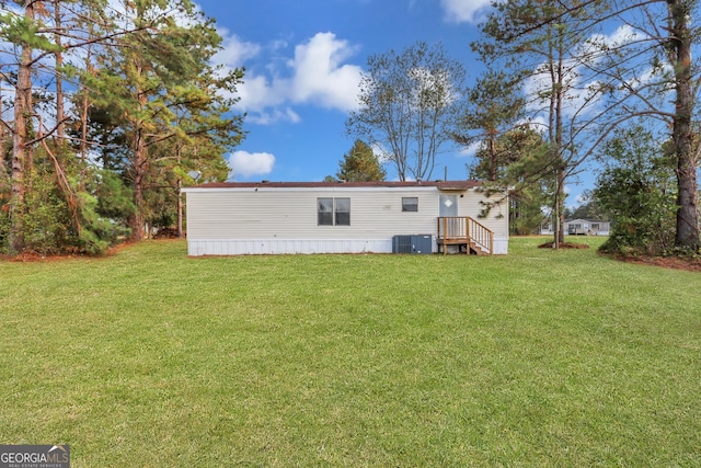 back of property with a yard and central AC unit