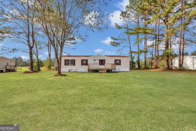 view of front of property with a deck and a front lawn