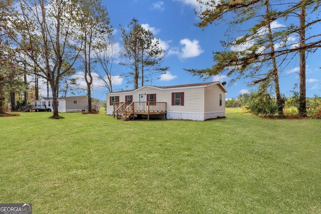 rear view of house featuring a deck and a yard