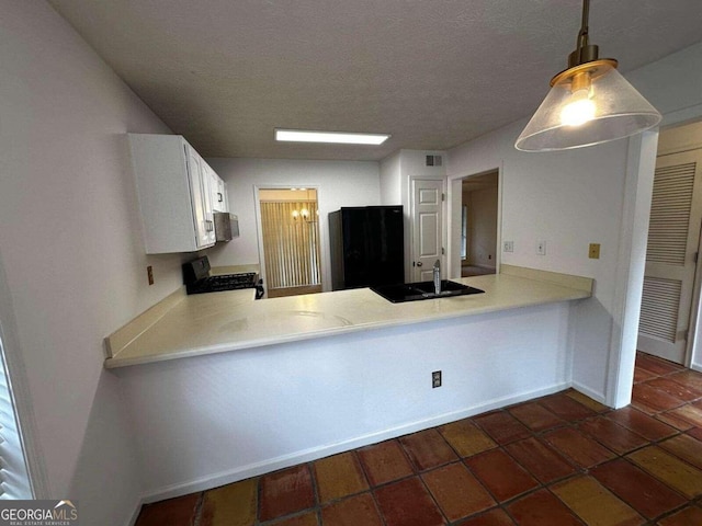 kitchen featuring kitchen peninsula, white cabinetry, black appliances, pendant lighting, and sink