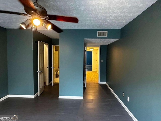 unfurnished bedroom featuring a textured ceiling and ceiling fan