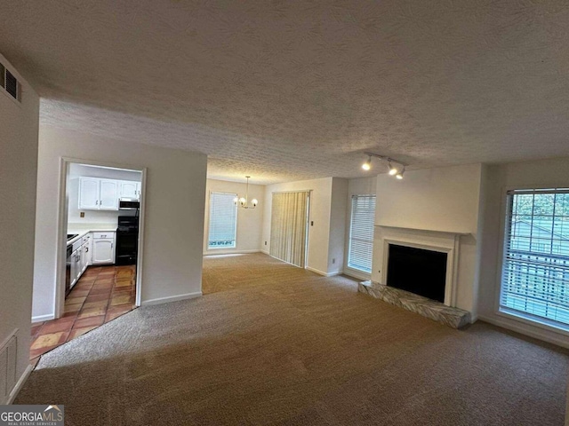 unfurnished living room with light tile patterned flooring, a textured ceiling, and an inviting chandelier