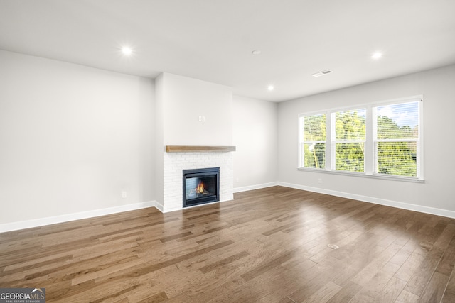 unfurnished living room featuring hardwood / wood-style floors and a fireplace