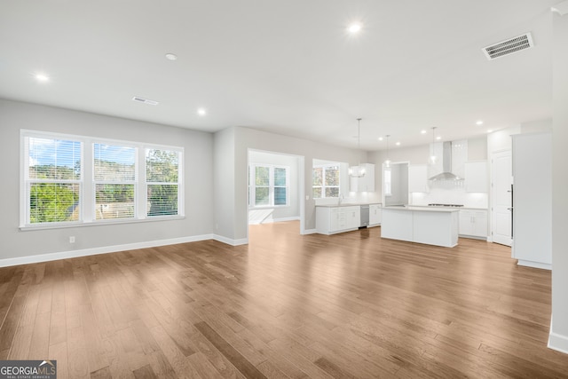 unfurnished living room featuring a healthy amount of sunlight and light hardwood / wood-style flooring