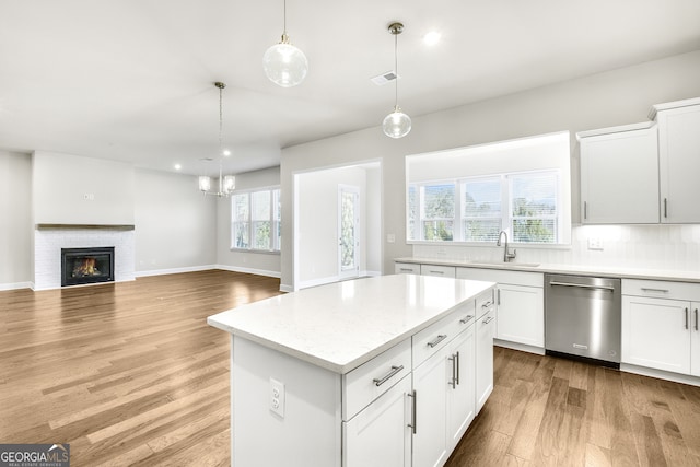 kitchen with a wealth of natural light, white cabinetry, dishwasher, and light wood-type flooring