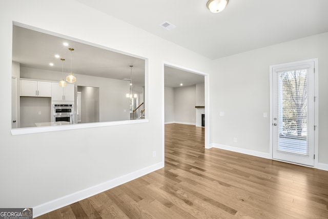 interior space featuring light hardwood / wood-style flooring and a notable chandelier