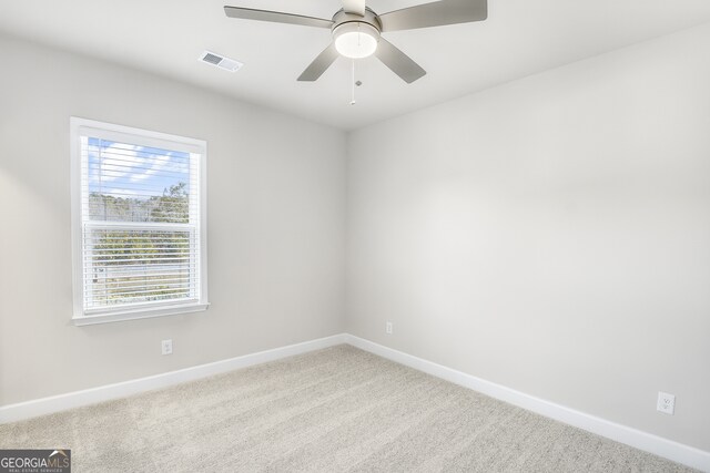 unfurnished room with ceiling fan and carpet