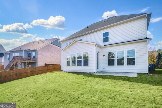 rear view of house featuring a lawn and a patio area