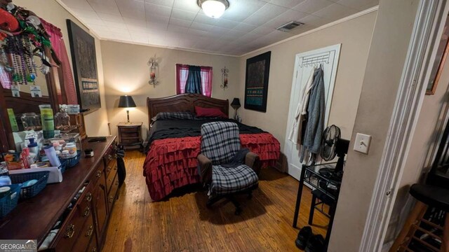 bedroom featuring ornamental molding and wood-type flooring