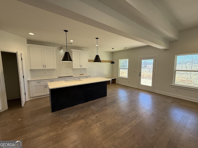 kitchen featuring decorative light fixtures, a center island, decorative backsplash, and white cabinets