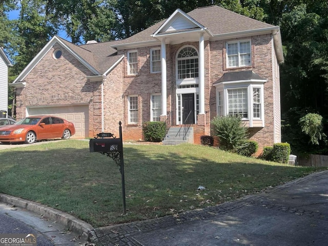 view of front of property with a front yard and a garage