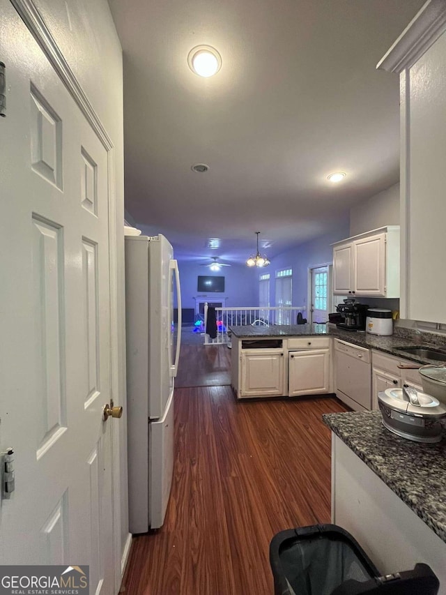 kitchen featuring white cabinetry, kitchen peninsula, dark hardwood / wood-style floors, and white appliances