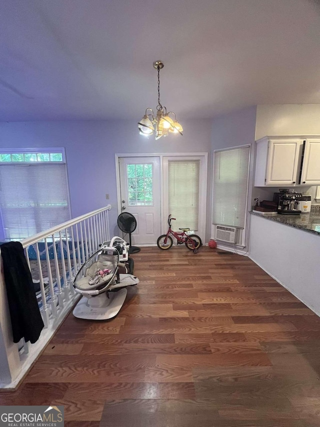 dining area featuring an inviting chandelier, cooling unit, and dark hardwood / wood-style flooring