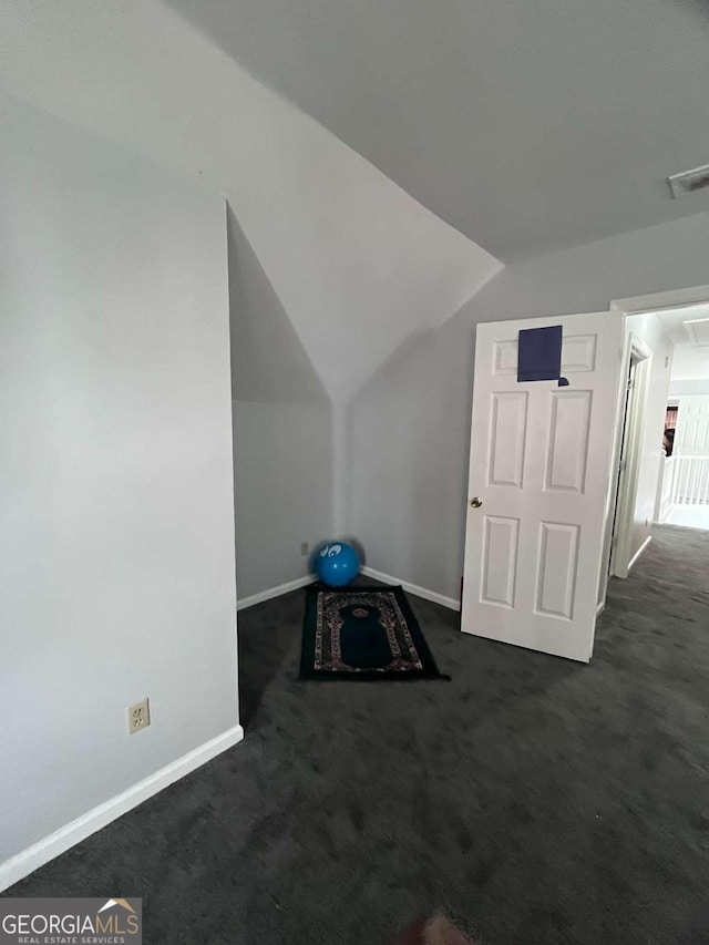 bonus room featuring dark carpet and vaulted ceiling