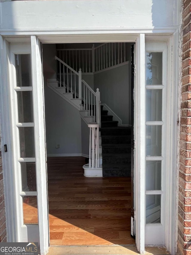 interior space featuring hardwood / wood-style floors and brick wall