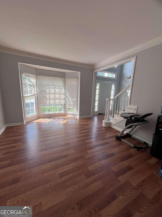 foyer entrance with ornamental molding and dark hardwood / wood-style floors