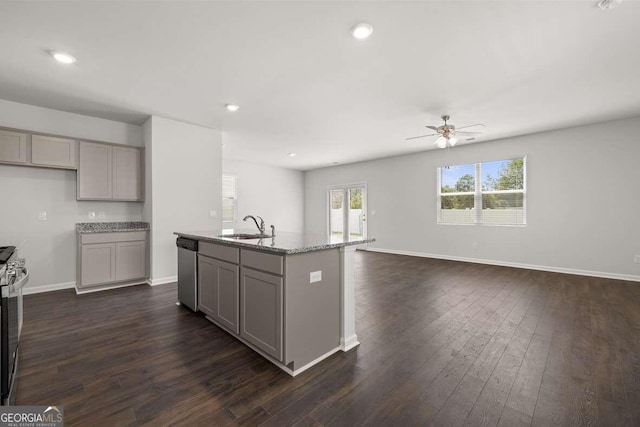 kitchen with sink, gray cabinetry, a center island with sink, appliances with stainless steel finishes, and light stone countertops