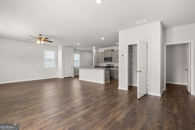 unfurnished living room featuring ceiling fan and dark hardwood / wood-style flooring