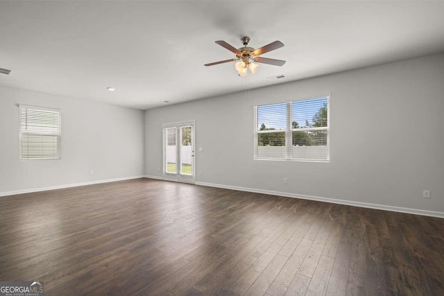 empty room with dark hardwood / wood-style flooring and ceiling fan