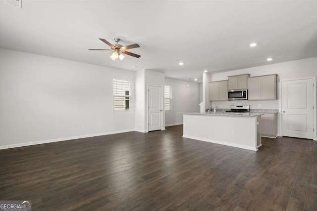 unfurnished living room with dark hardwood / wood-style flooring and ceiling fan