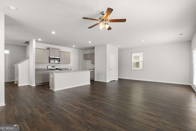 unfurnished living room with ceiling fan and dark hardwood / wood-style floors