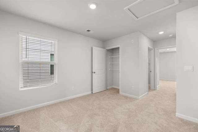 unfurnished bedroom featuring light carpet and a closet