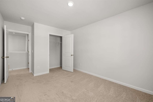 unfurnished bedroom featuring a closet and light carpet