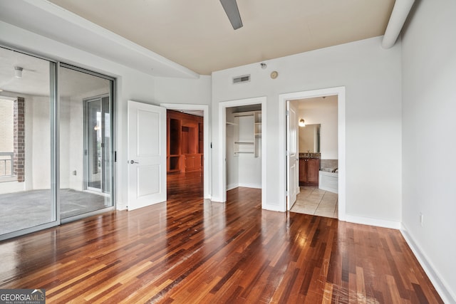 unfurnished bedroom with connected bathroom, a closet, hardwood / wood-style floors, and ceiling fan