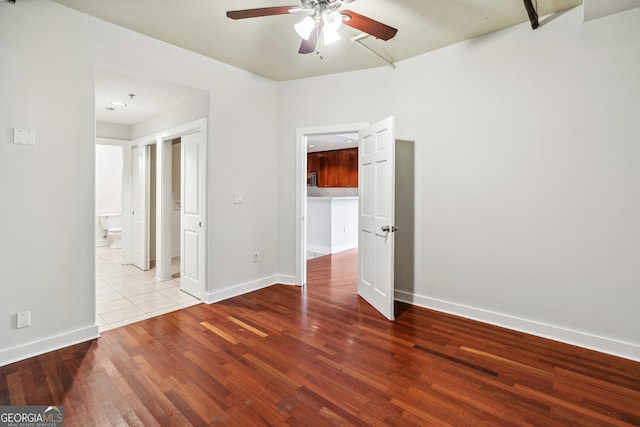 empty room with ceiling fan and light hardwood / wood-style flooring